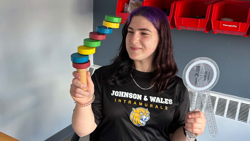 Sofia at her internship holding some equipment she uses with clients