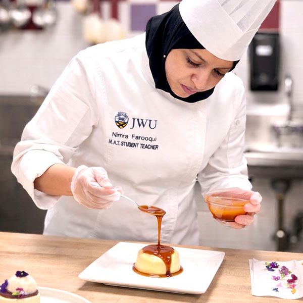 Nimra Faqooqui plating a dessert as part of a lesson plan. 
