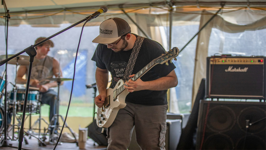Musician playing guitar alongside band