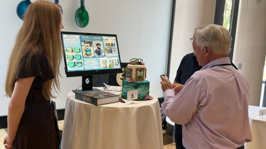 Sara Warner presenting her project, Monet-Inspired Speciality Cake Exhibit, to people