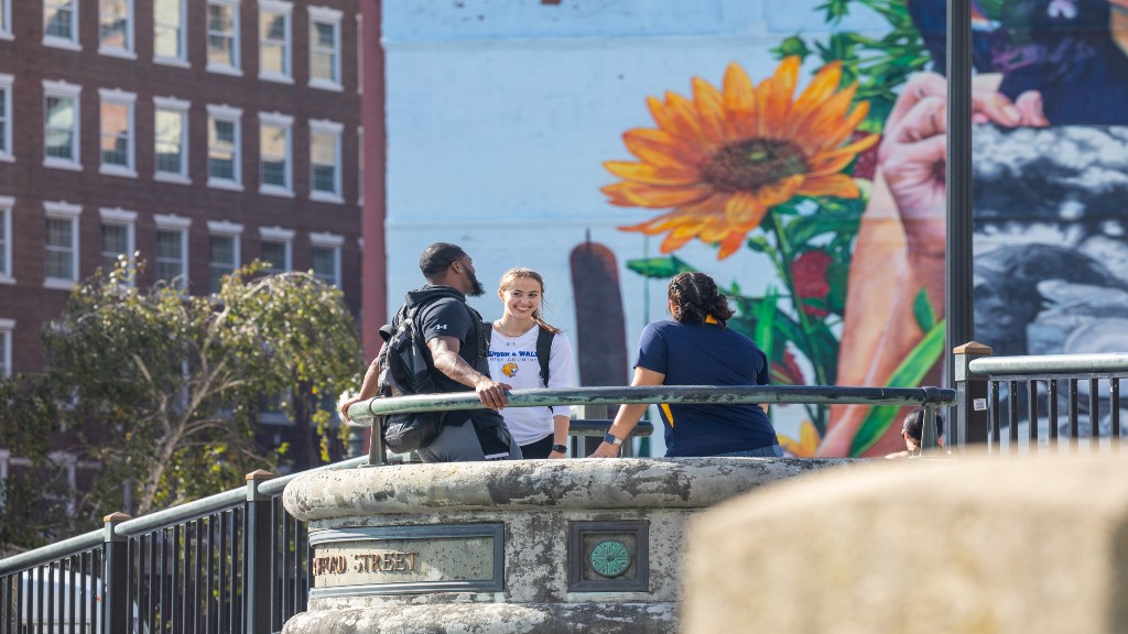 students hanging out in front of mural downtown