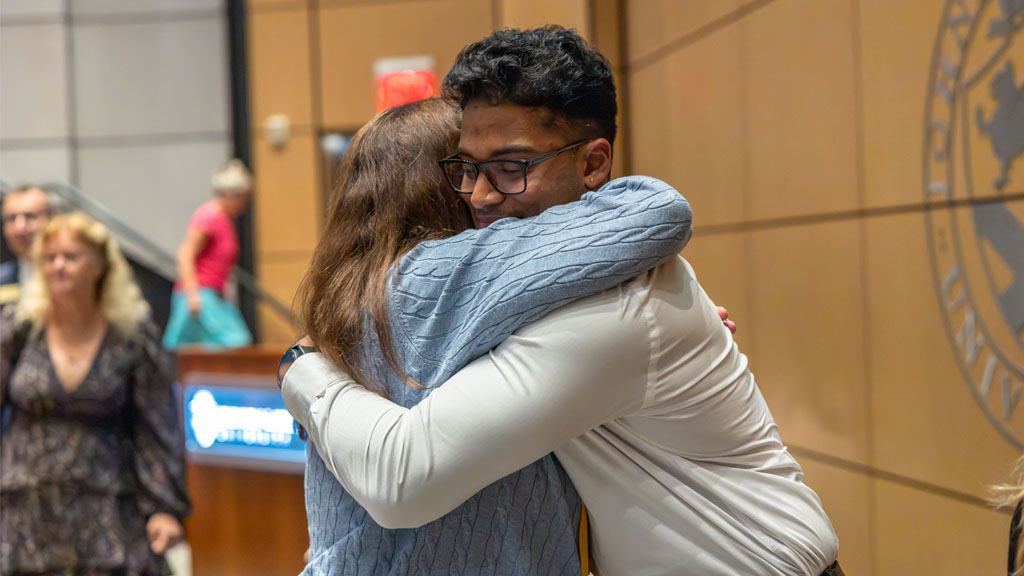 Two people hugging, soaking in the moment. 