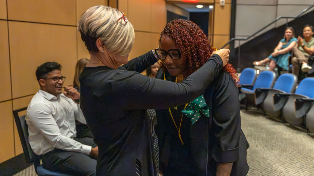A student receiving her ribbon from the nursing pining ceremony.