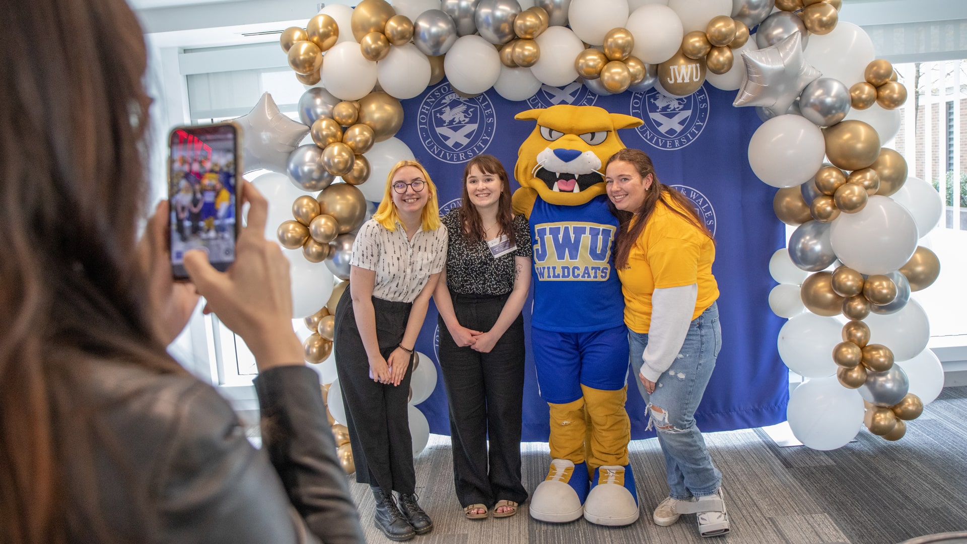 Students pose at the Symposium with Wildcat Willie.