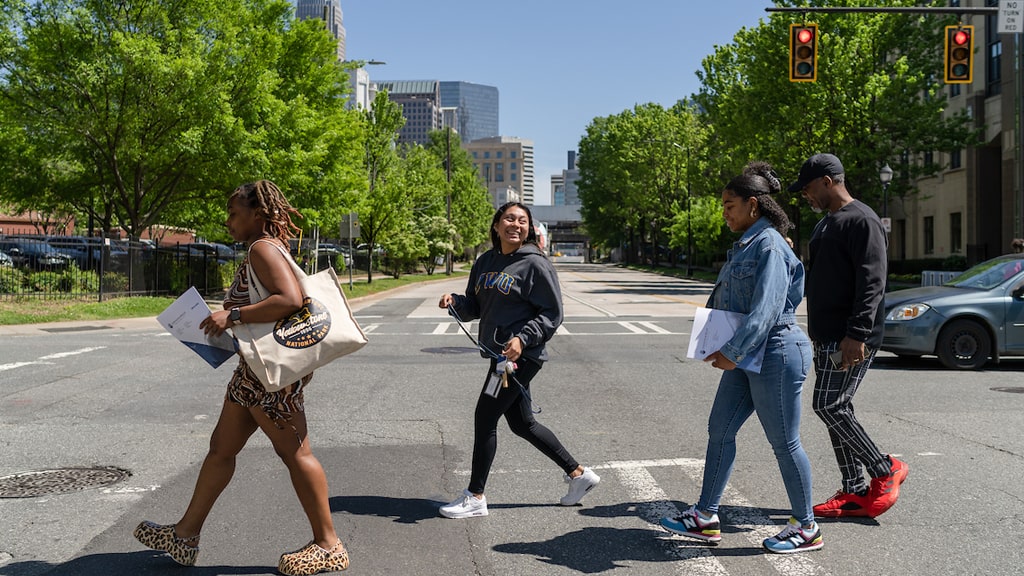 Four commuter students crossing a road in downtown Charlotte