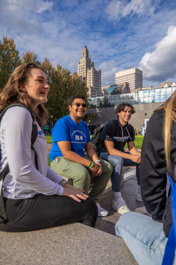 Students sitting on Gaebe Commons, smiling and laughing together.