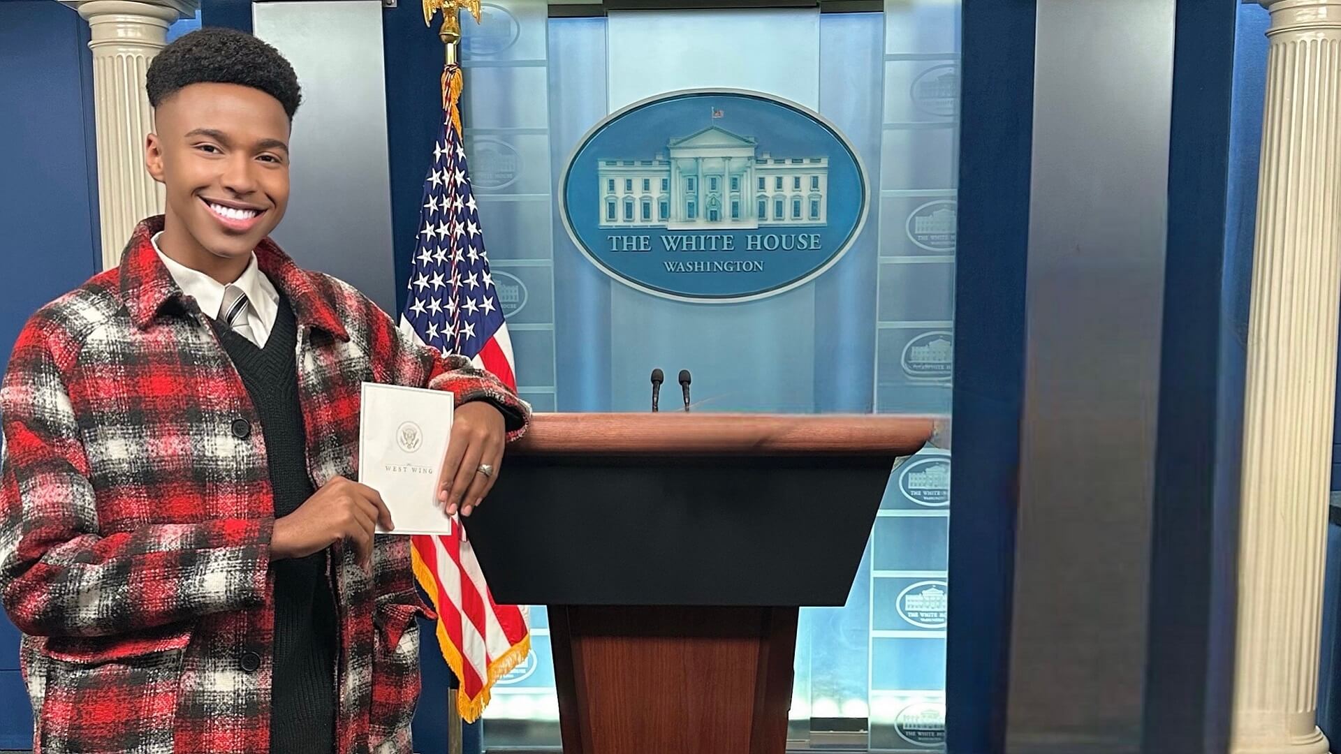 JWU student Alijah Jamison interns at white house and stands next to podium
