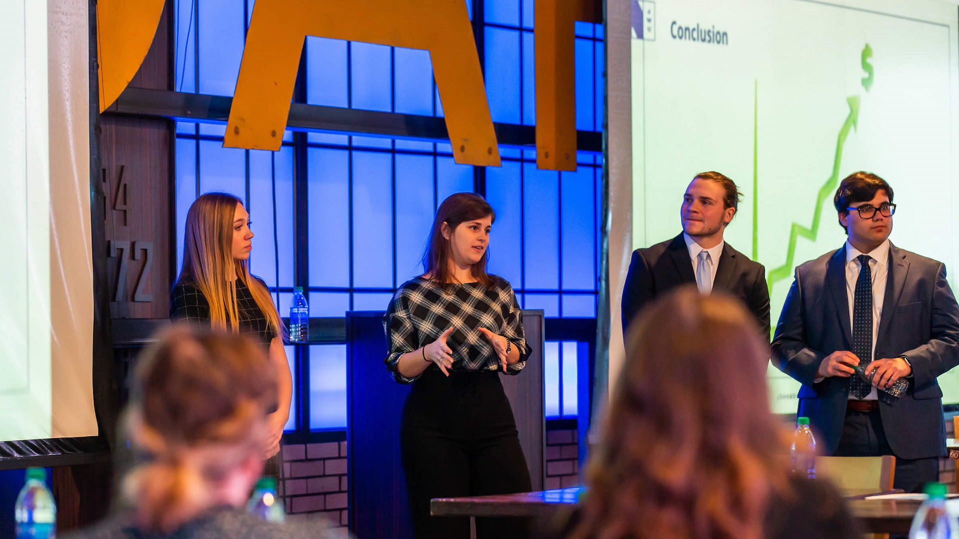 Four JWU business students on a panel in front of an audience.