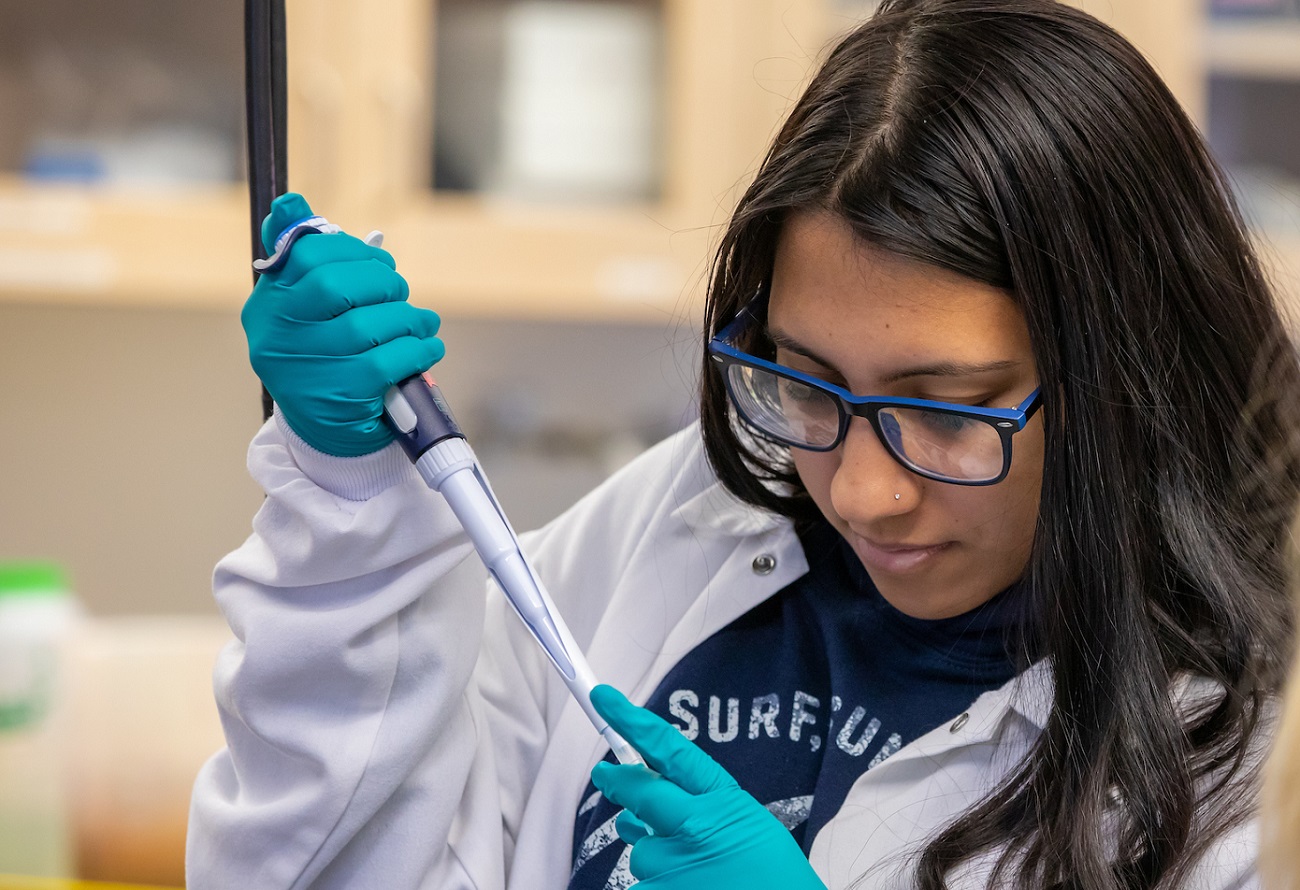 student in lab using equipment