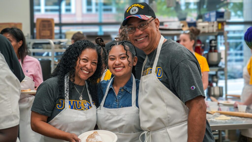 student and parents smiling in cooking workshop