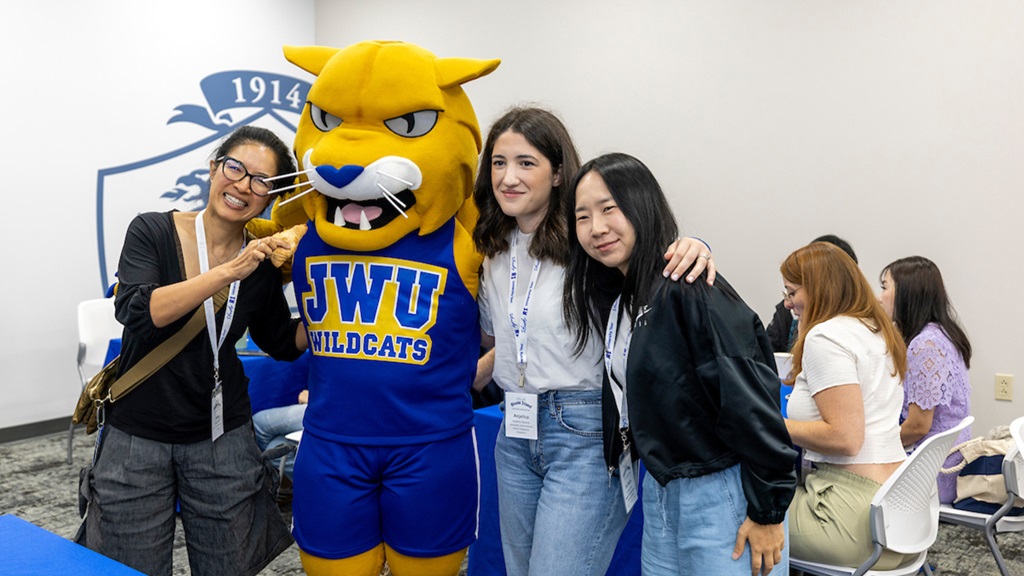 group of international students posing with JWU Mascot Wildcat Willie