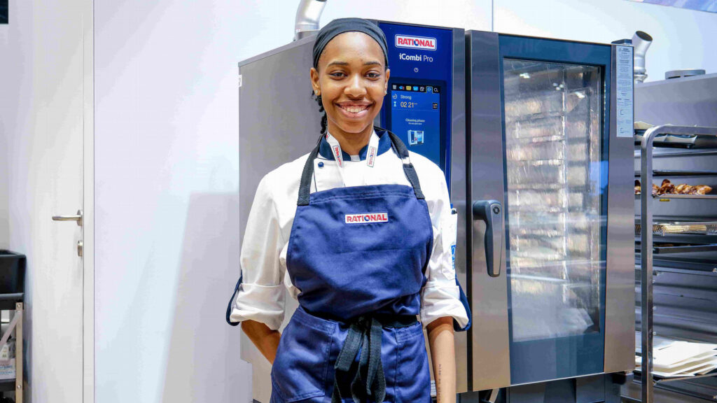 Mali Towe stands in front of a Rational combi oven.