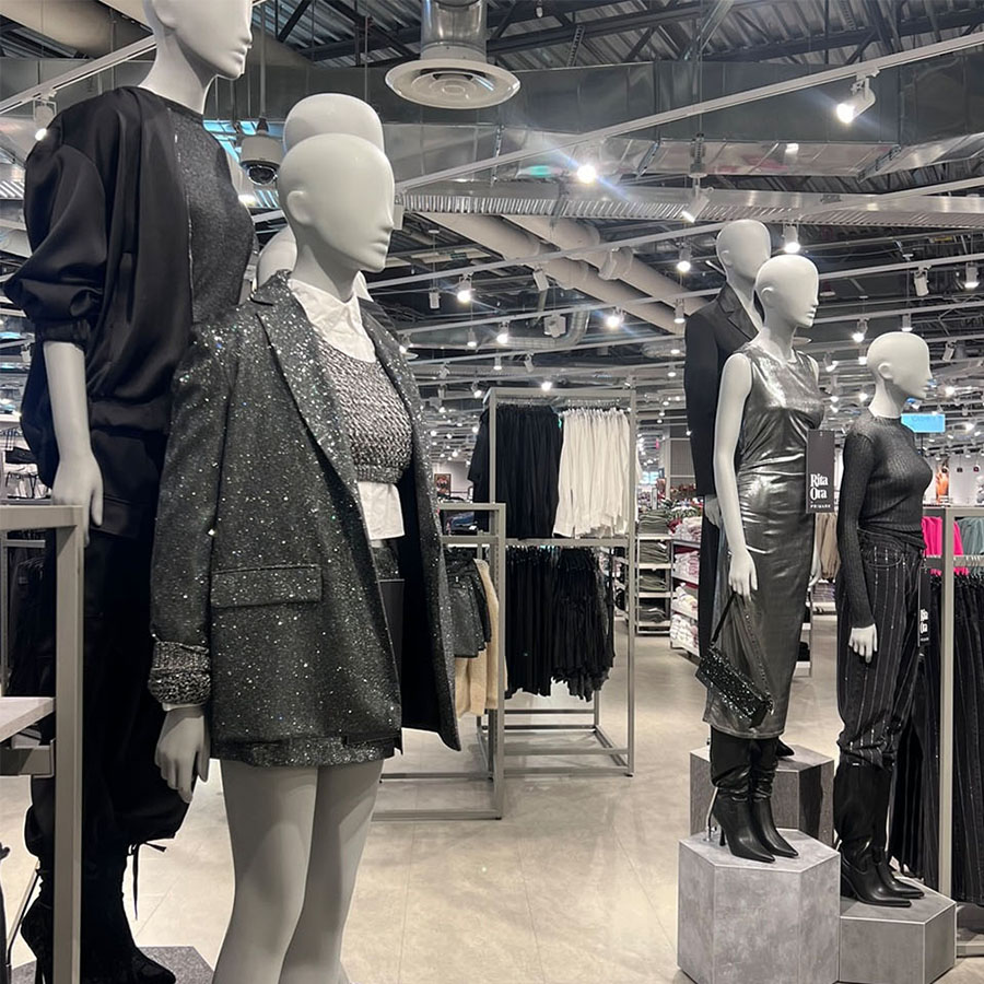 Mannequins dressed in fancy clothing in a fashion store.
