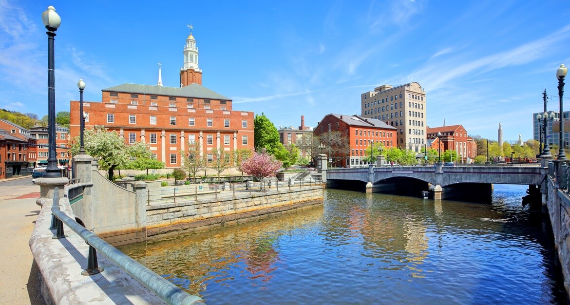 Exterior of JWU Providence campus building and river walkway in the summertime