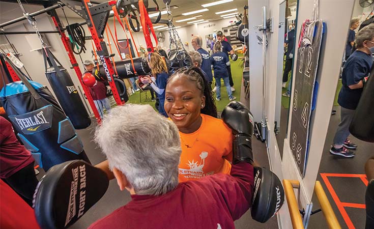 Geraldine Gibson ’25 OTD helps a client with Parkinson's complete a therapeutic workout.