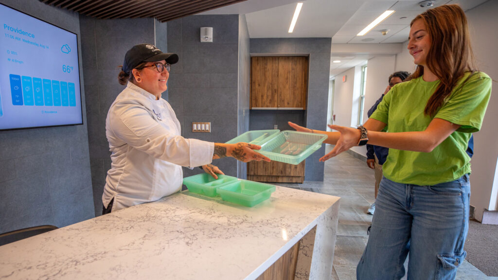 A student grabs an eco-friendly to-go container at a JWU Providence dining hall.