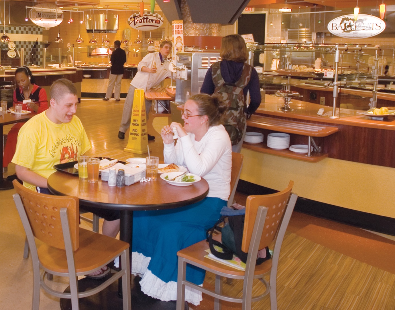 Students socialize at a table in the dining hall on campus