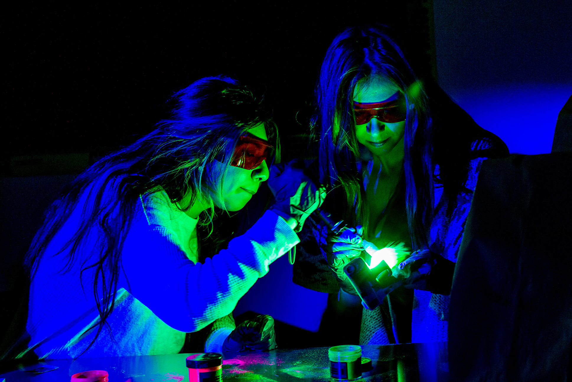 Students use forensic lights to examine evidence during a criminal justice lab activity.