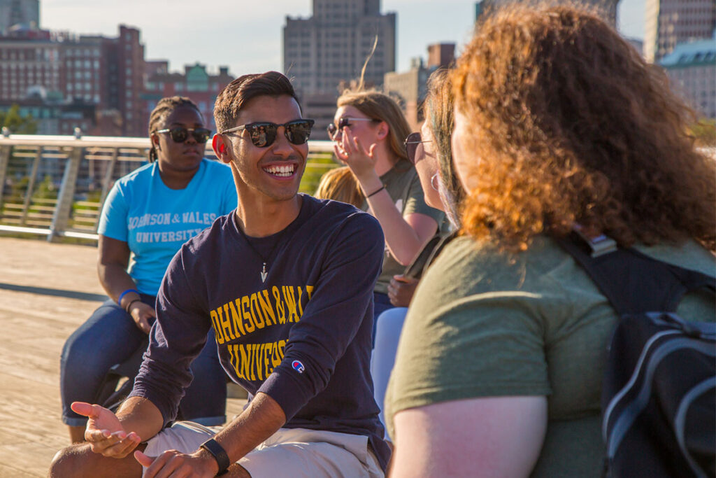Students smiling and talking together on the Providence River Pedestrian Bridge.