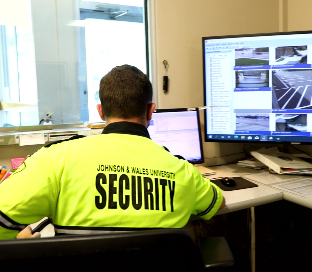 A campus safety and security officer monitors live surveillance feeds to ensure a safe learning environment