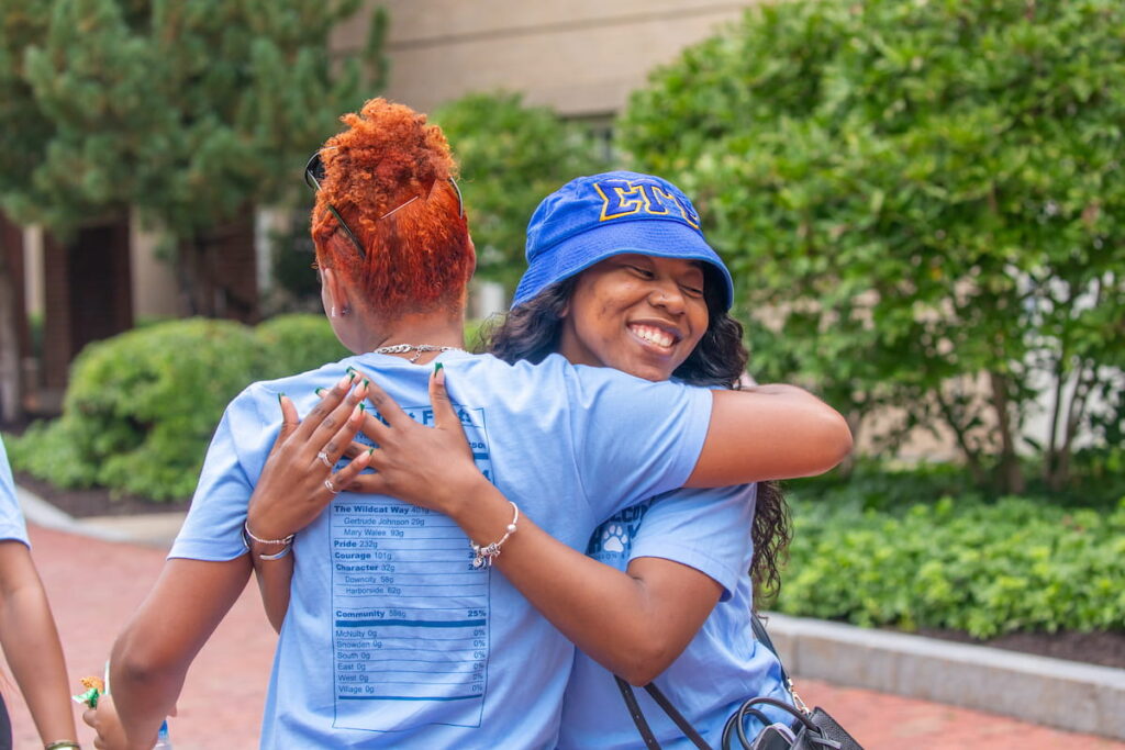 Two students embracing each other outside on the Charlotte campus.