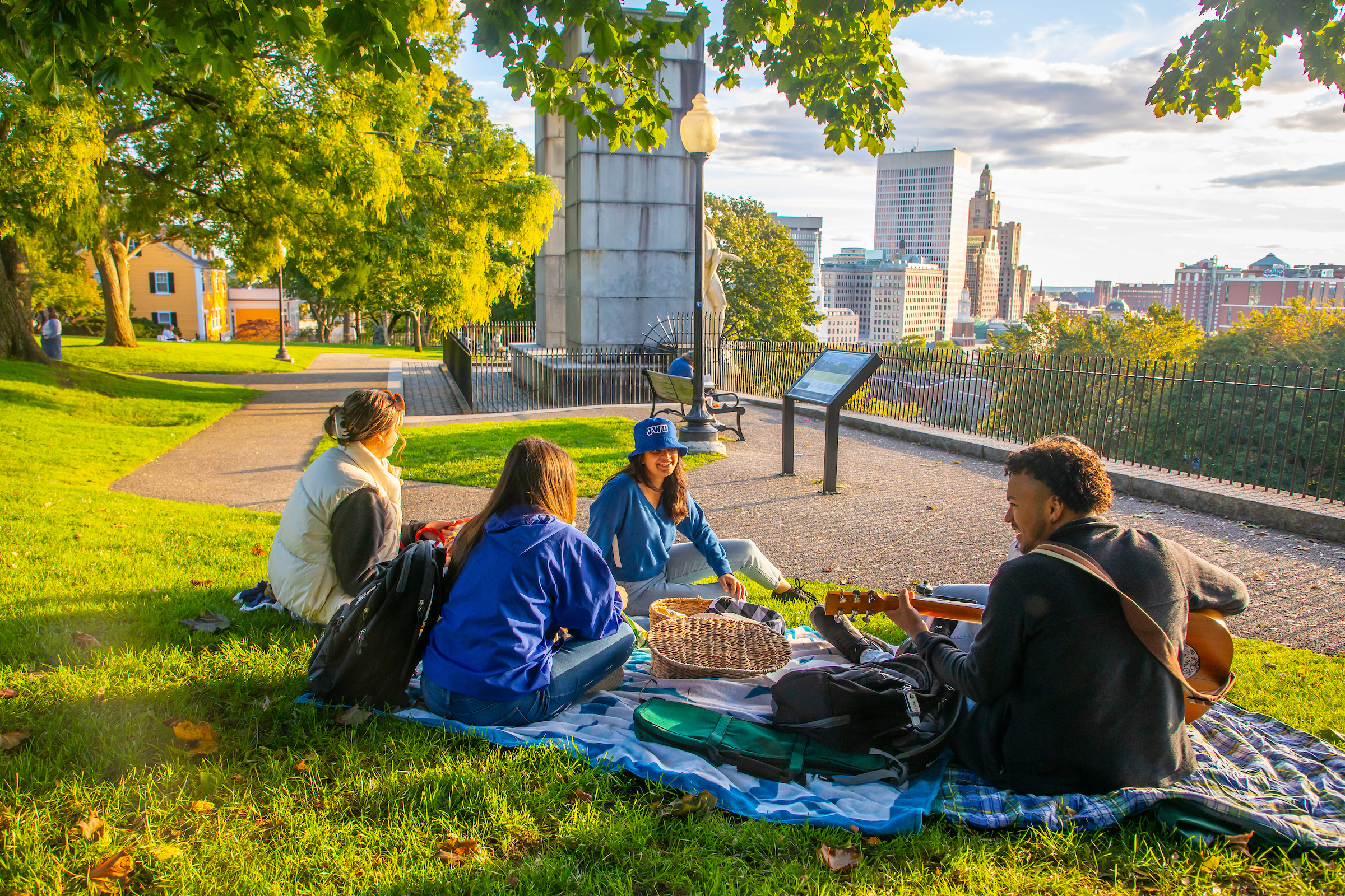 Students having a picnic near Roger Williams statue overlooking Providence