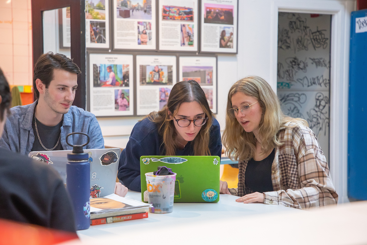 Graphic Design students looking at project on laptop