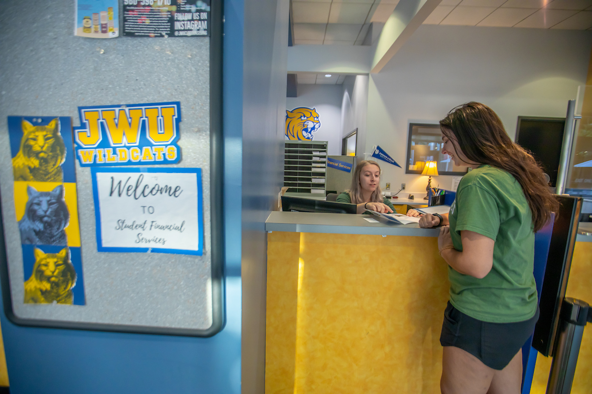 Student Financial Services interior w student taling to staff