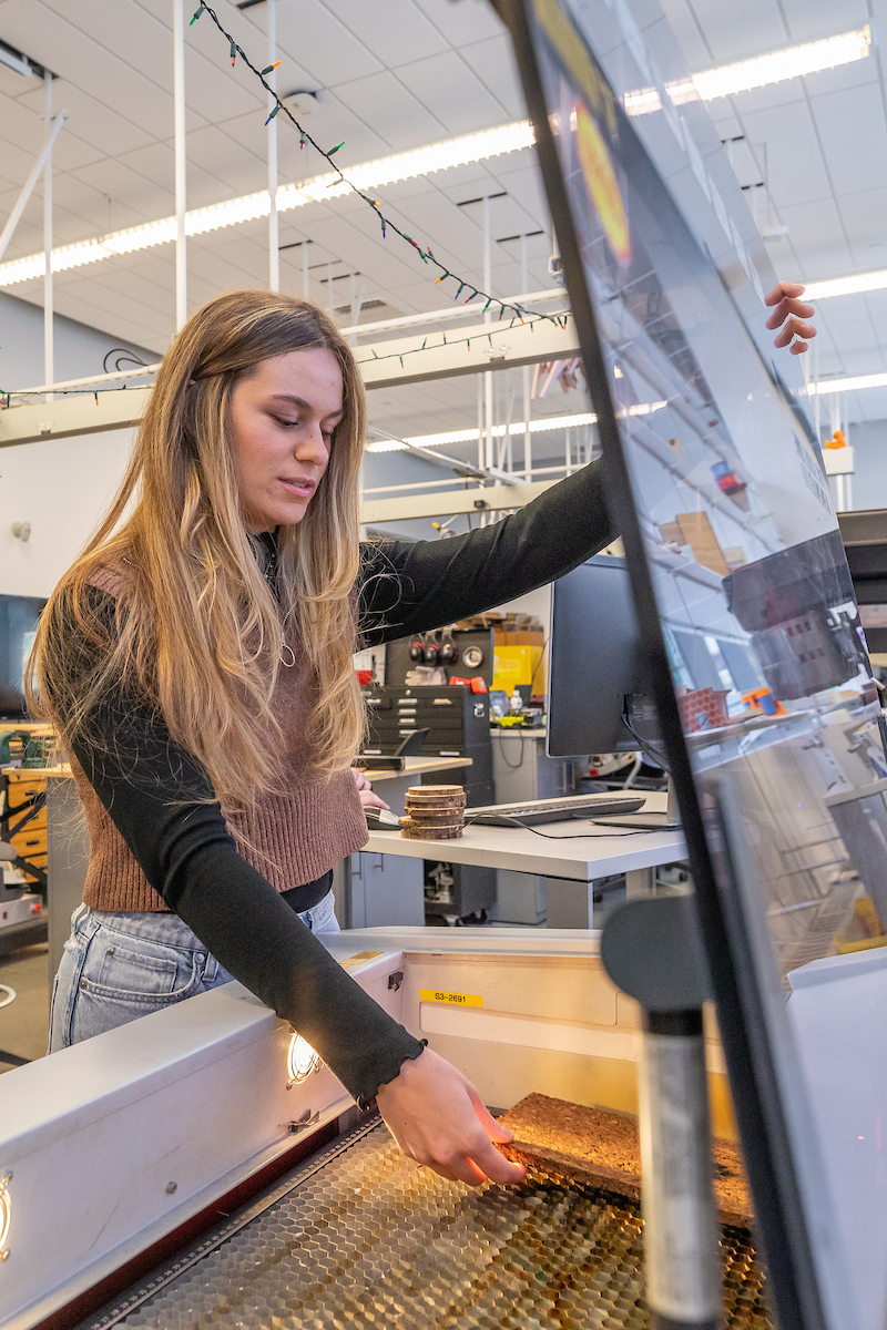 A student works with an engraving machine in a Bowen design lab.