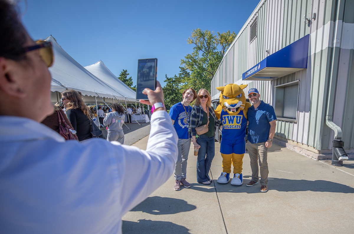 Family poses with WIldcat Wilie during Homecoming