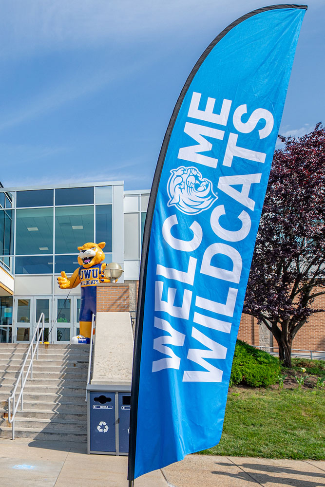 A banner reading Welcome Wildcats in front of the Wildcat Center on Harborside campus, with a blow up statue of Wildcat Willie in the background.