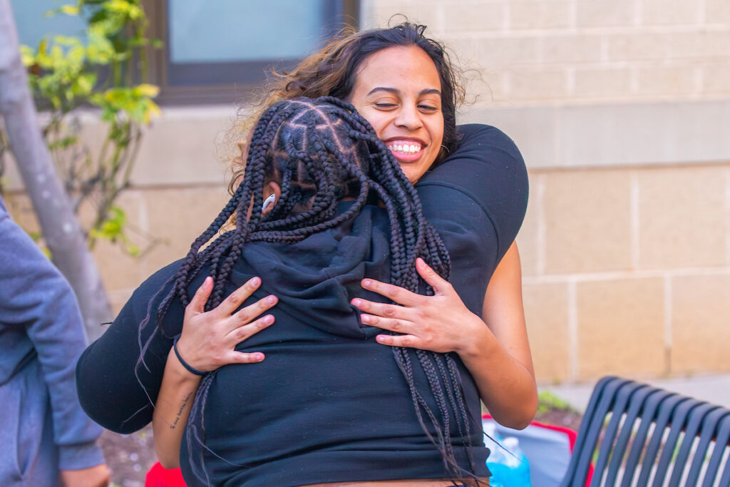 Charlotte students hugging each other and smiling