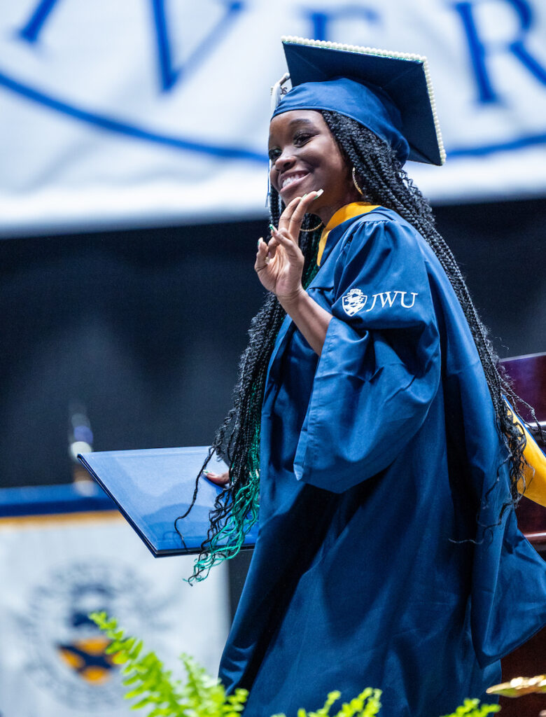 Feamle students celebrates after receiving her diploma 