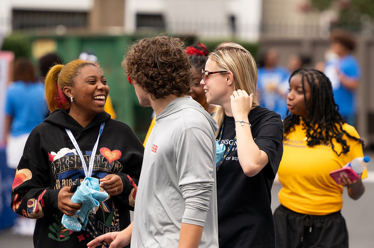 A group of students having a cheerful conversation while walking outdoors.