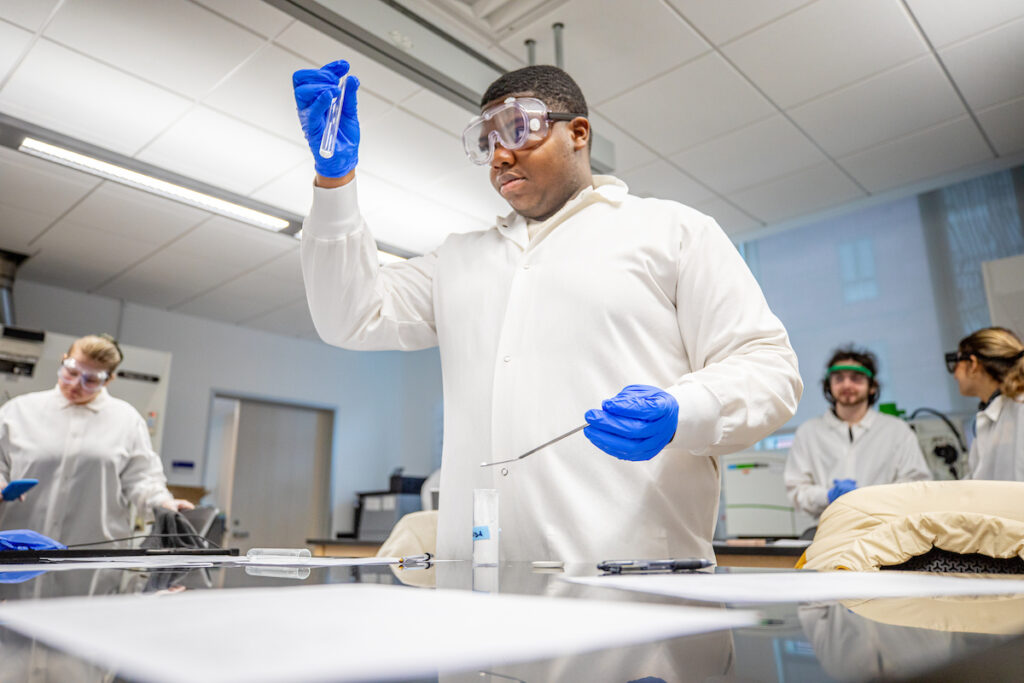 Student with beeker in biology lab