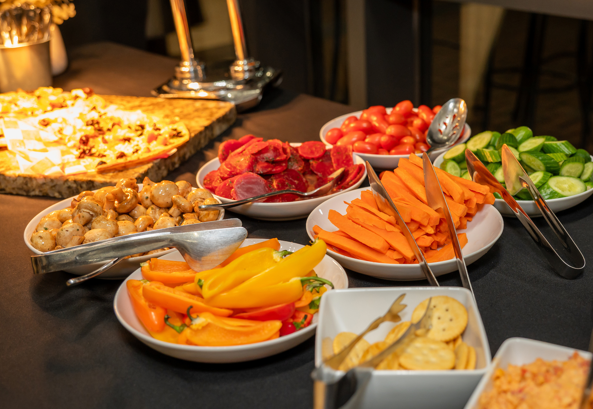 A vibrant buffet table displays an array of fresh vegetables, cheeses, and appetizers with a Mediterranean theme.
