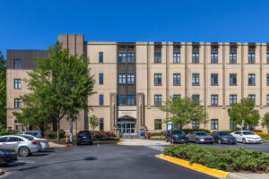 Front view of Cedar Hall South with cars in the parking lot on a sunny day at Johnson & Wales University Charlotte Campus.