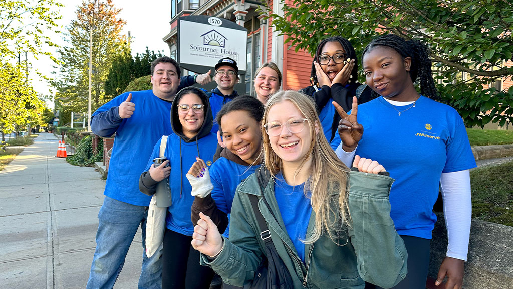 smiling volunteers in front of Sojourner House