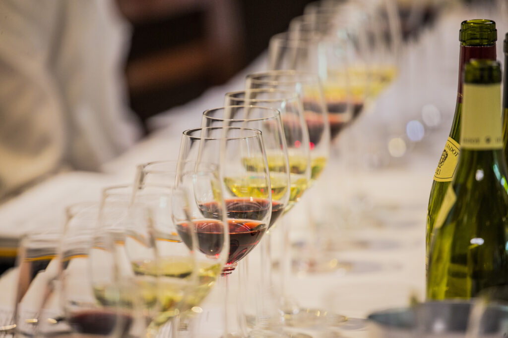 A row of wine glass half-filled with white and red wine.
