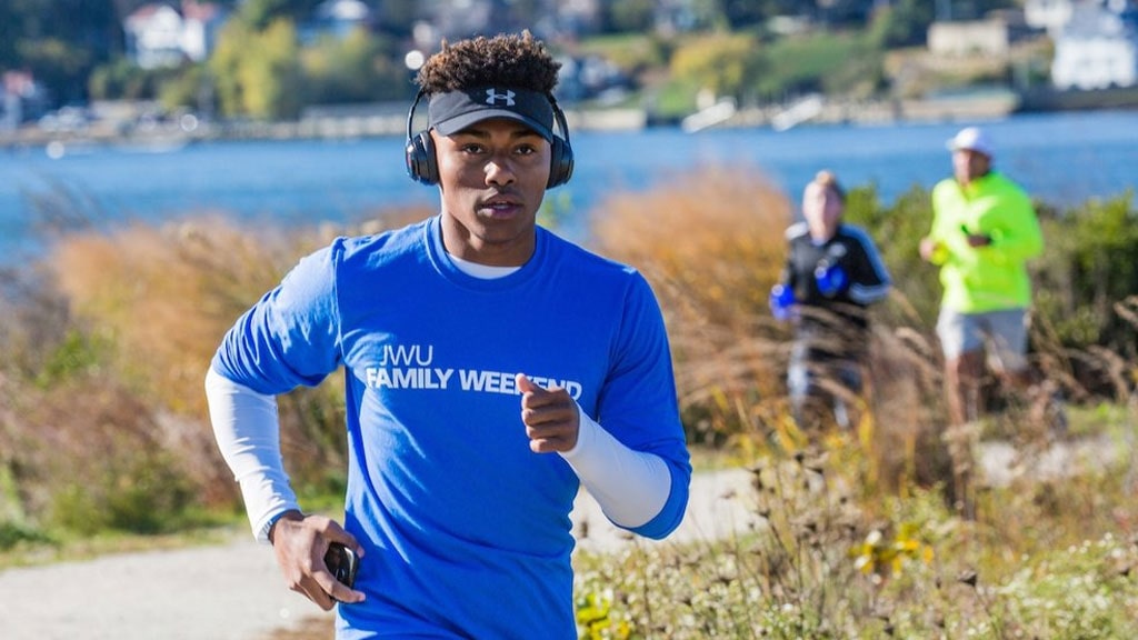 young man running along the water