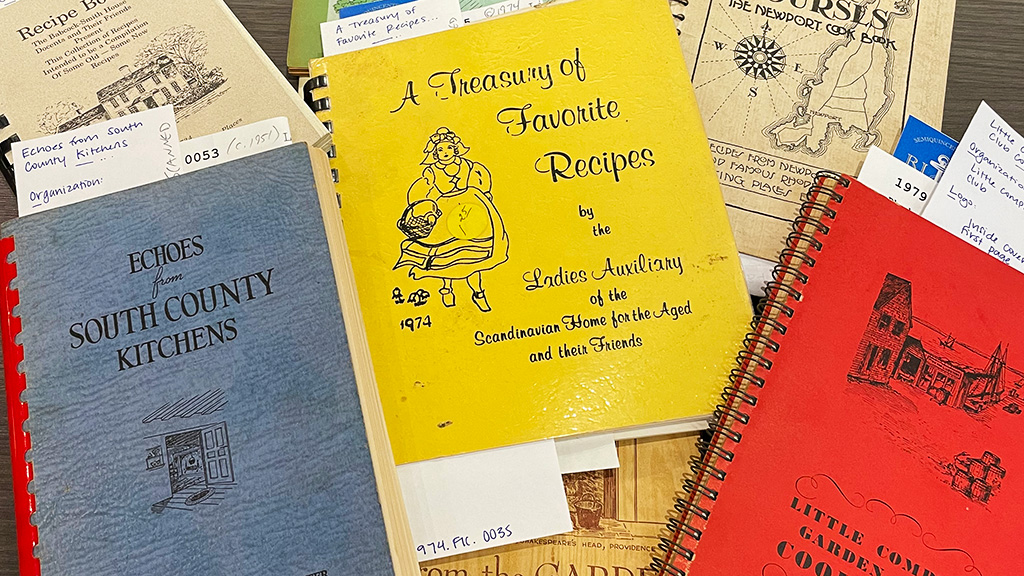 Collection of archived cookbooks with blue, yellow and red covers.