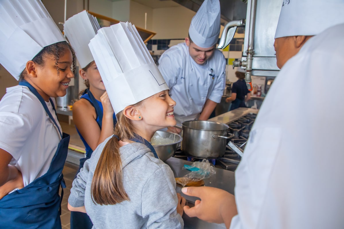 Elementary school chefs taking part in a culinary class during Summer Camp.