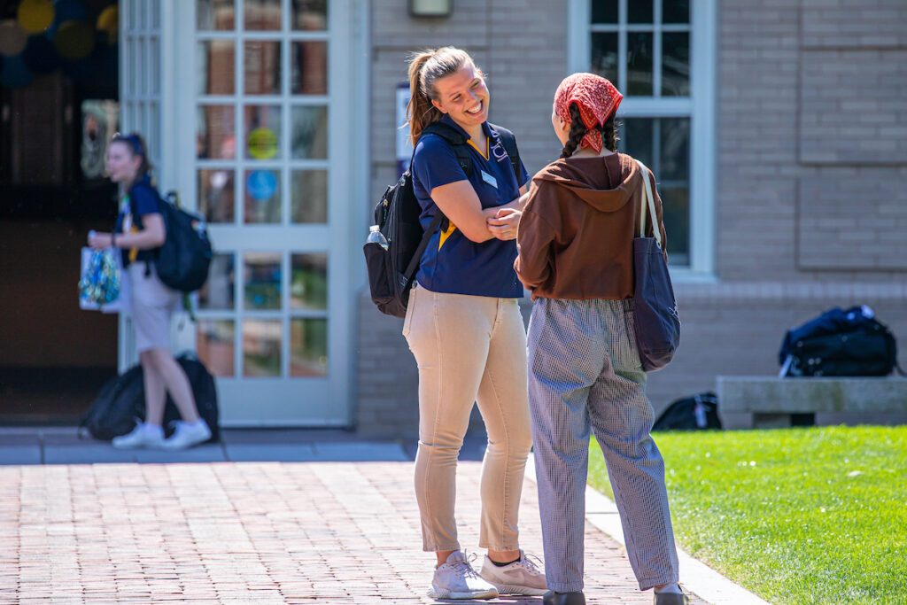 Two students chatting outside a residence hall on Gaebe Commons.
