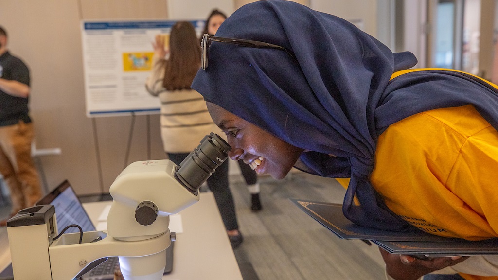 student looking through microscope