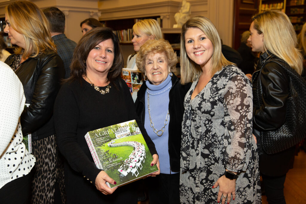 Alexandra Derosa smiling at an event with two women.