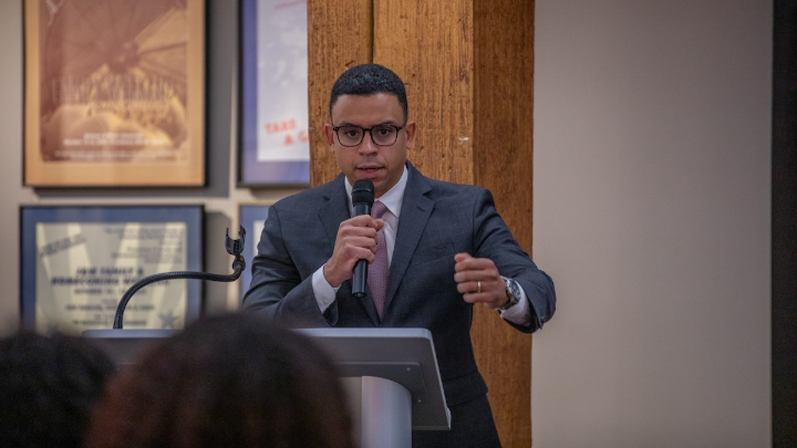 Arnaldo Almonte ’09 speaks to the crowd at a podium.