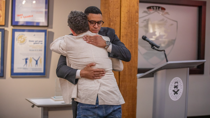 Arnaldo Almonte ’09 and President Greene embrace.
