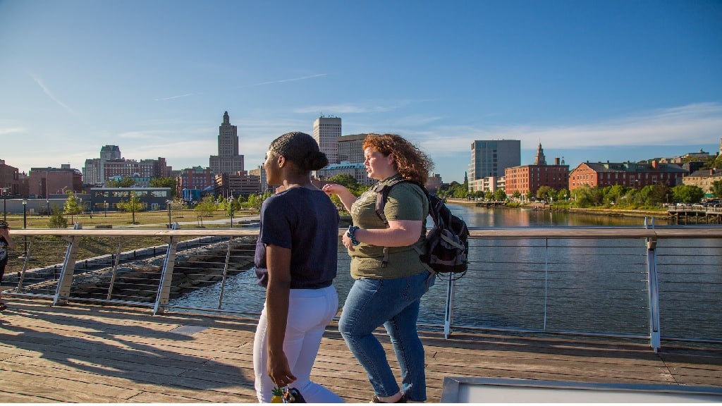 two girls talking and walking a bridge