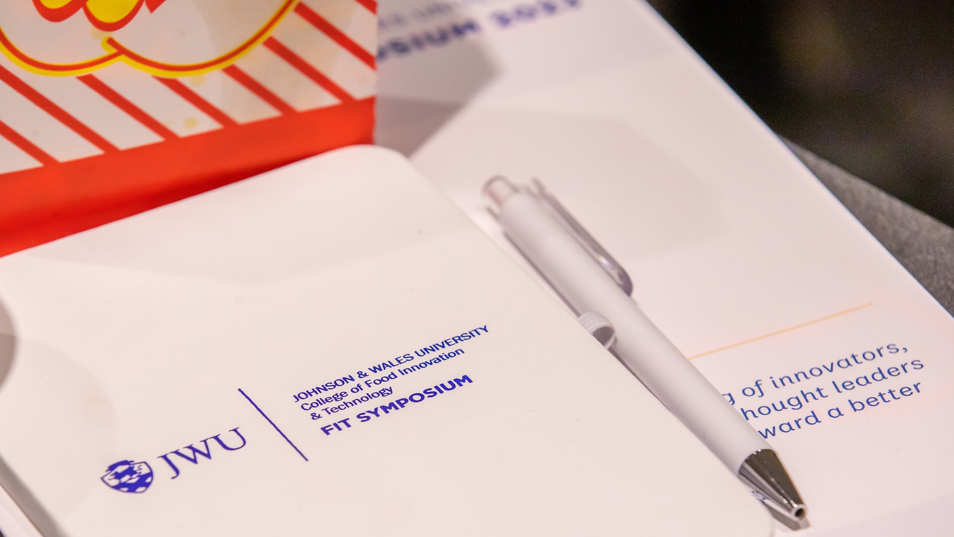 Notebooks, stationery and pens branded with the logo of JWU Providenceu2019s 2023 FIT Symposium.