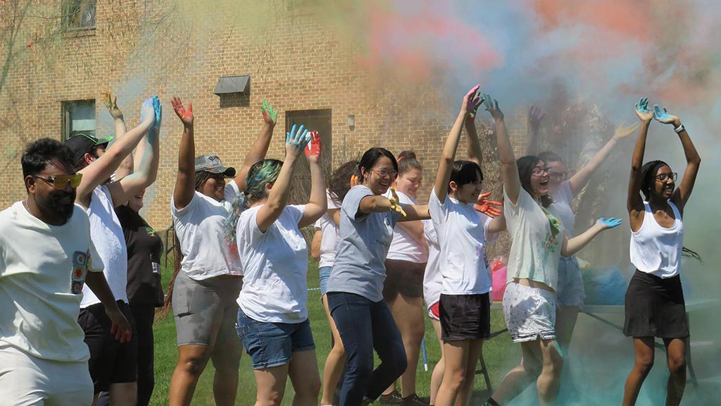 group of college students throwing colored chalk
